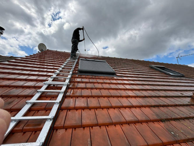 Artisan couvreur en train de nettoyer une toiture en tuiles plates à basse pression — nettoyage toiture 91, TG Couverture